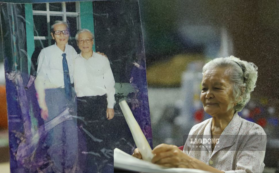 Bà Phan Thị Cấu vẫn (vợ cố nhà giáo Lê Đức Giảng) xem lại bức ảnh chụp chung của chồng và Tổng Bí thư Nguyễn Phú Trọng. Ảnh: Phương Thảo