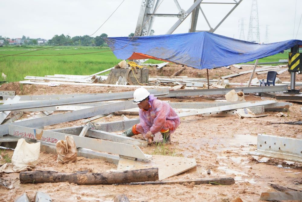 Ghi nhận tại vị trí móng cột số 173 (thuộc địa bàn xã Đông Hoàng, huyện Đông Sơn, tỉnh Thanh Hóa), dù trời mưa nhưng các cán bộ, công nhân ngành điện vẫn mặc áo mưa để thi công. Ảnh: Quách Du