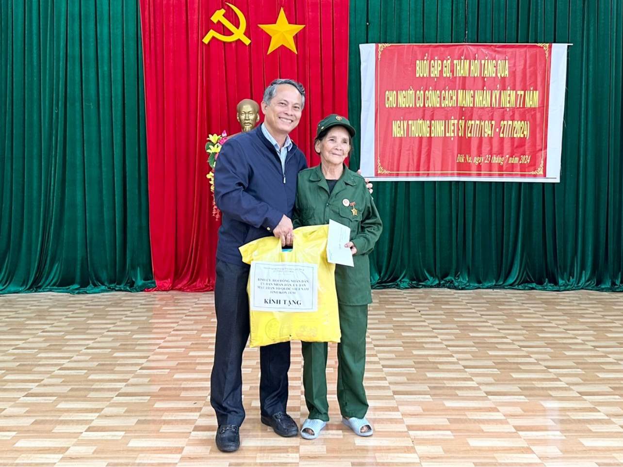 Chairman of the People's Committee of Tu Mo Rong district presented gifts to people who contributed to the revolution. Photo: Huyen Nga