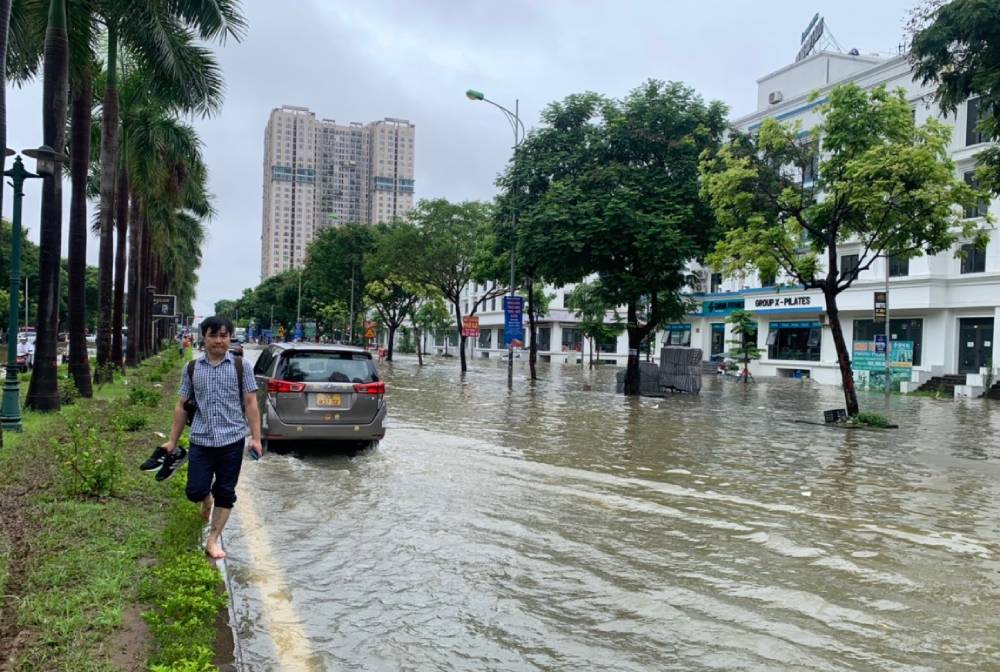 Many people have to wade through water to get to work. Photo: Vuong Tran