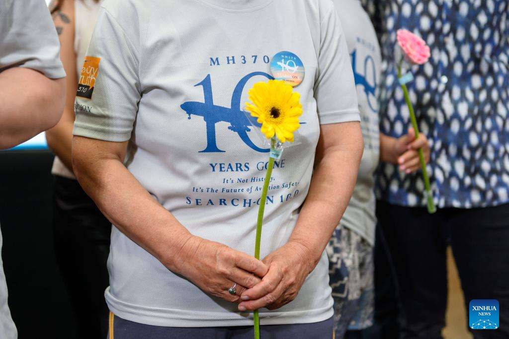 People hold flowers at an event marking 10 years since MH370 disappeared in Subang Jaya, Selangor state, Malaysia, March 3, 2024. (Photo: Chong Voon Chung/Xinhua News Agency)