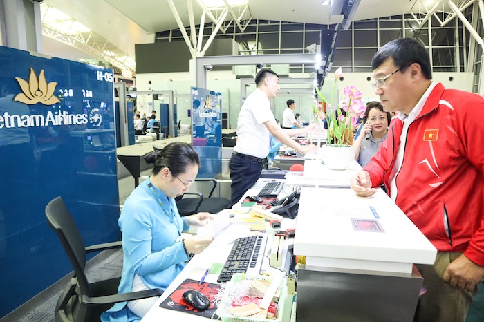 Các thành viên Đoàn thể thao Việt Nam làm thủ tục lên máy bay. Ảnh: Bùi Lượng