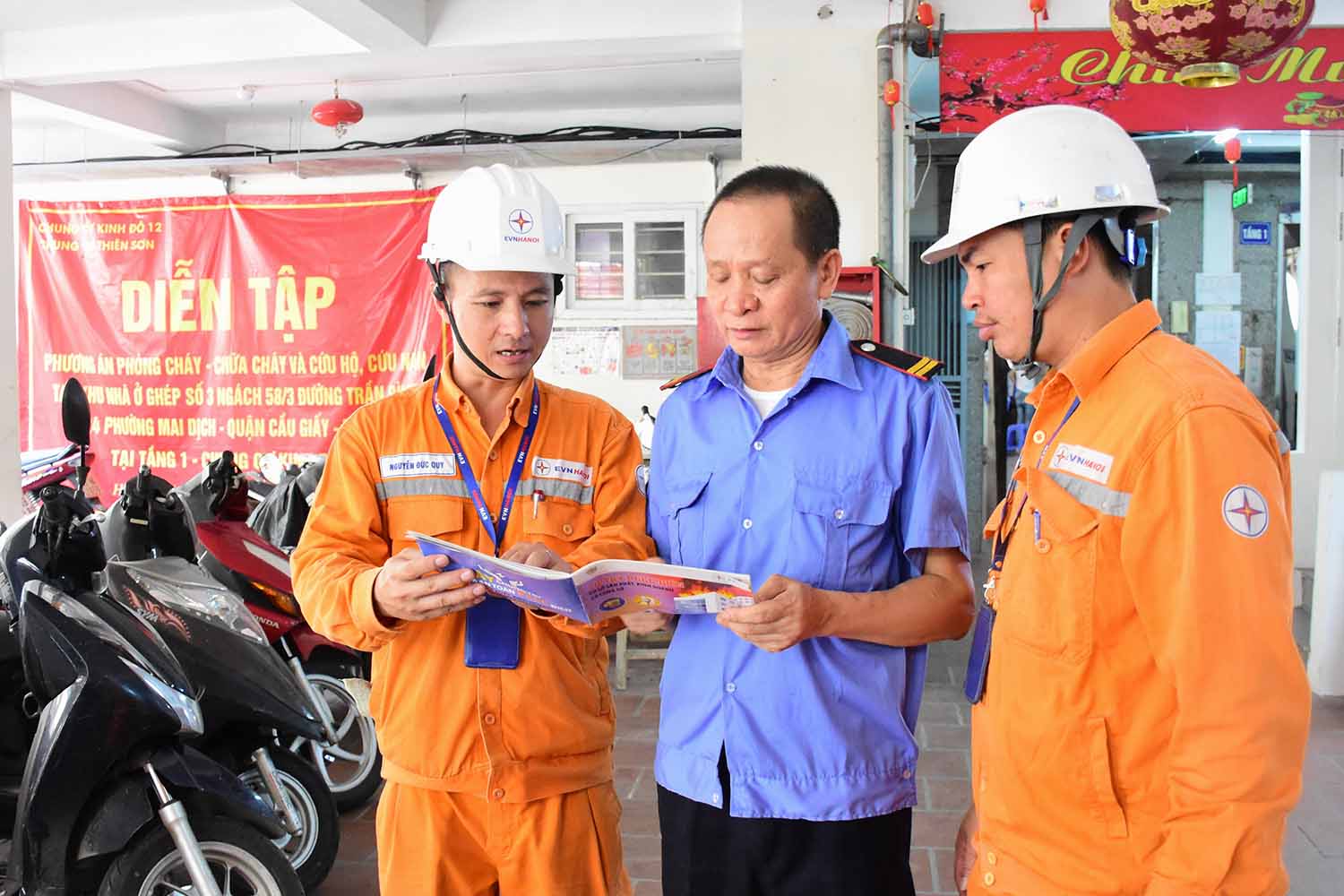 Người dân thuộc quận Cầu Giấy nhận “Sổ tay phòng cháy chữa cháy”. Ảnh: EVNHANOI.