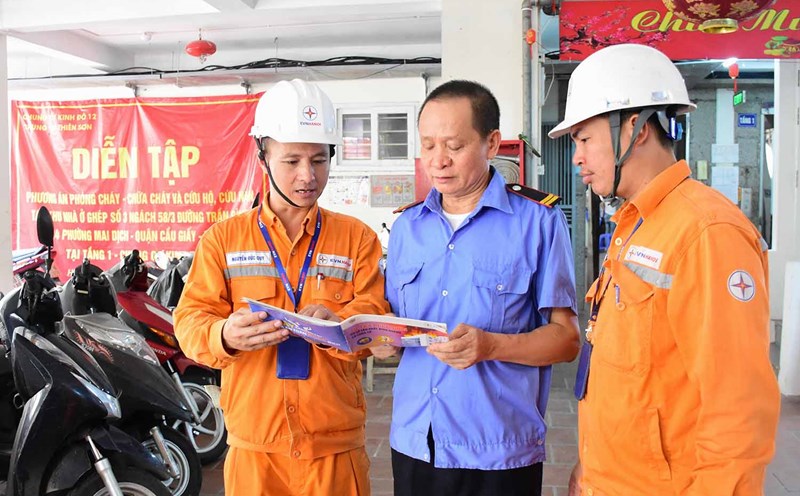 Người dân thuộc quận Cầu Giấy nhận “Sổ tay phòng cháy chữa cháy”. Ảnh: EVNHANOI.