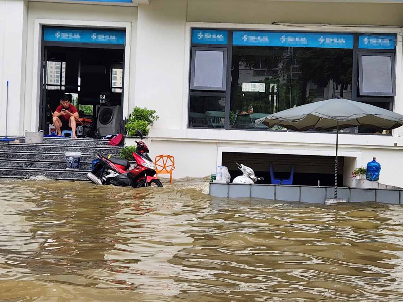 Nhiều người dân thuê nhà tại khu liền kề phải dừng hoạt động kinh doanh, các tài sản để phía dưới hầm bị chìm sâu trong nước. Ảnh: Cao Nguyên.