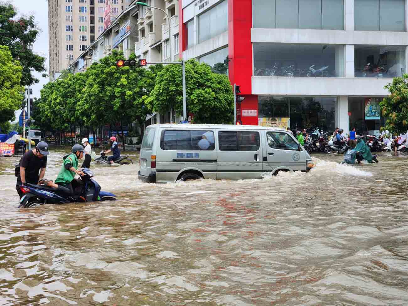 Some motorbikes and cars tried to pass through the flooded road but their engines stalled. Photo: Cao Nguyen.