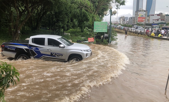 Xe ô tô gầm cao đi qua đoạn đường bị nước ngập sâu. Ảnh: Thục Quyên 