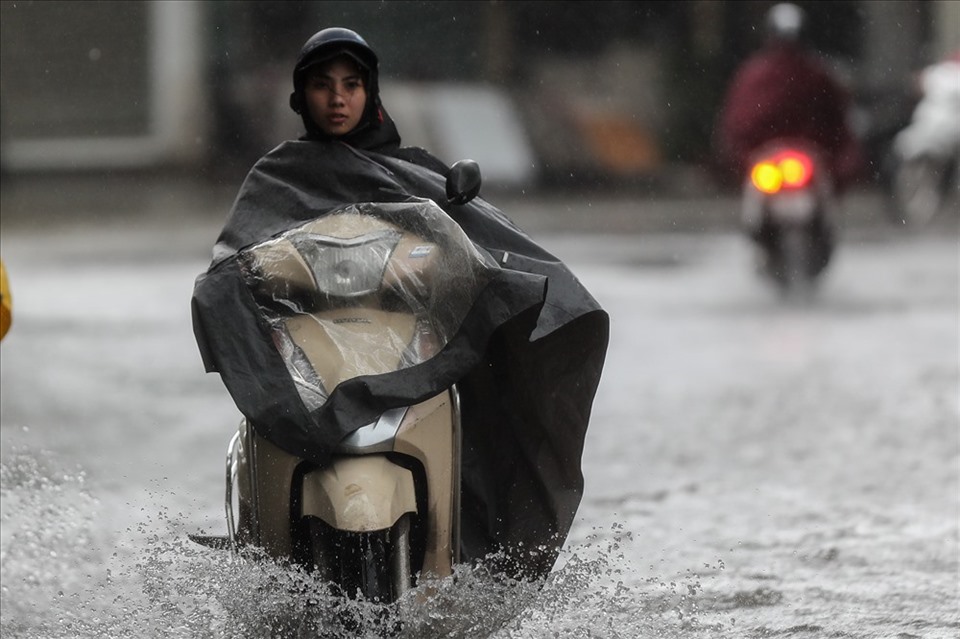 Công nhân chạy xe máy đi làm mùa mưa bão cần chú ý để đảm bảo an toàn. Ảnh: Sơn Tùng. 