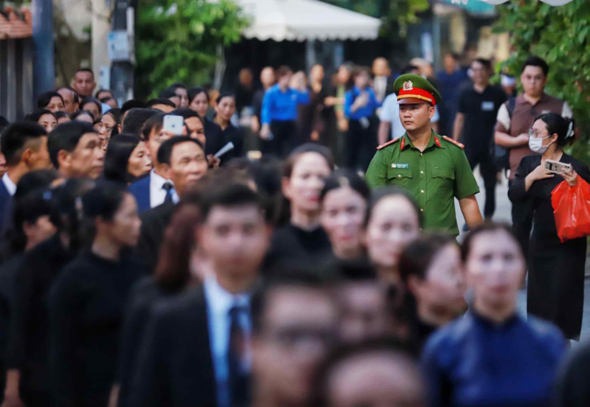 Lực lượng chức năng liên tục di chuyển dọc tuyến đường dẫn vào Nhà văn hóa thôn Lại Đà để hướng dẫn người dân. Ảnh: Tô Thế