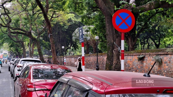 Biển cấm đỗ liền kề với biển điểm trông giữ xe tại đường Văn Miếu. Sở GTVT Hà Nội cho biết, điểm trông giữ xe chỉ là cấp phép tạm thời. Ảnh: Đền Phú

