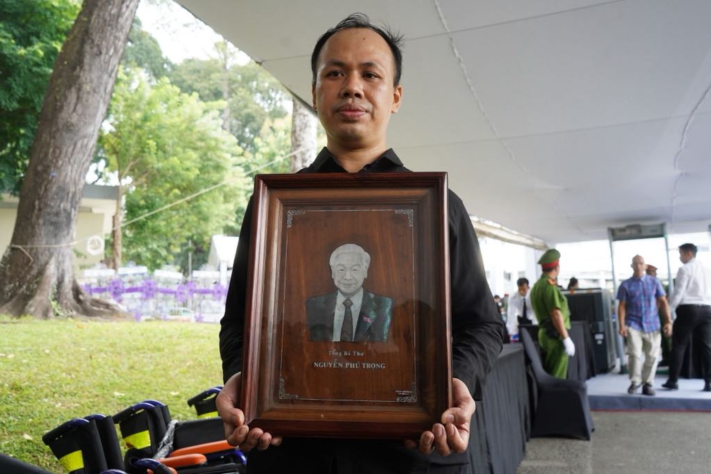 Artist Nguyen Phu Huynh holds a photo of General Secretary Nguyen Phu Trong made of pearl inlay on wood. Photo: Mr. Tu