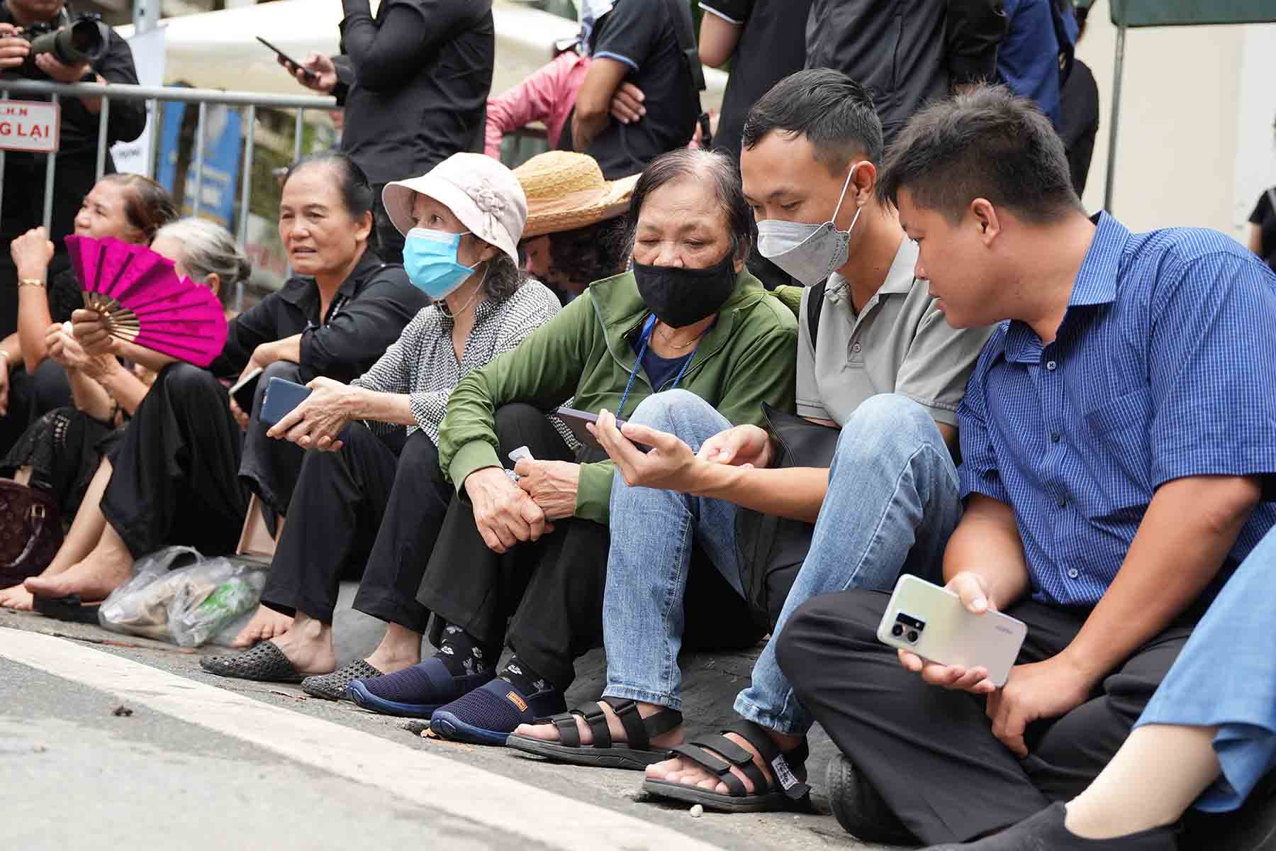 Trong lúc chờ đợi vào trong Nhà tang lễ, nhiều người dân đã tập trung chứng kiến lễ viếng Tổng Bí thư qua chương trình truyền hình trực tiếp. 