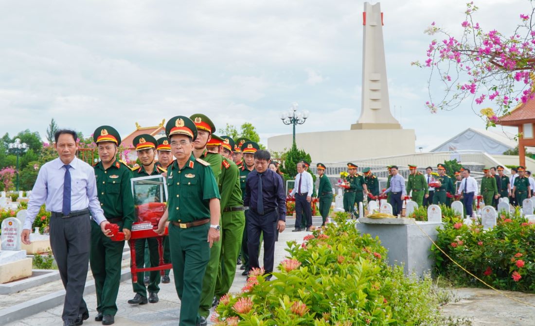 Lãnh đạo các đơn vị đưa các hài cốt liệt sĩ đến các phần mộ để an táng. Ảnh: Hưng Thơ.