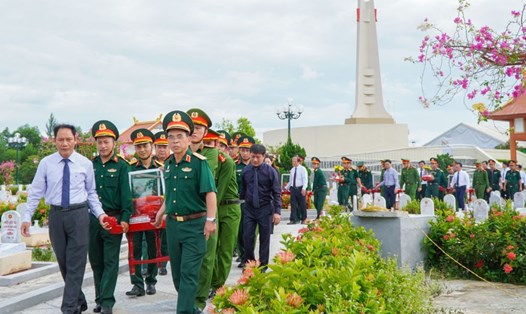 Lãnh đạo các đơn vị đưa các hài cốt liệt sĩ đến các phần mộ để an táng. Ảnh: Hưng Thơ.