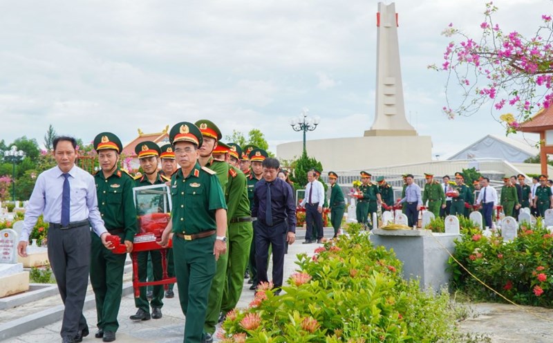 Lãnh đạo các đơn vị đưa các hài cốt liệt sĩ đến các phần mộ để an táng. Ảnh: Hưng Thơ.