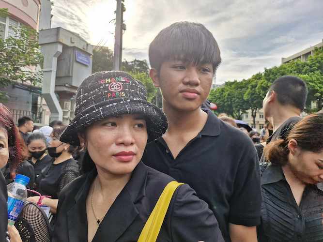 Even though the weather was very hot, Ms. Diep and her son still waited in line. Photo: Lan Nhi