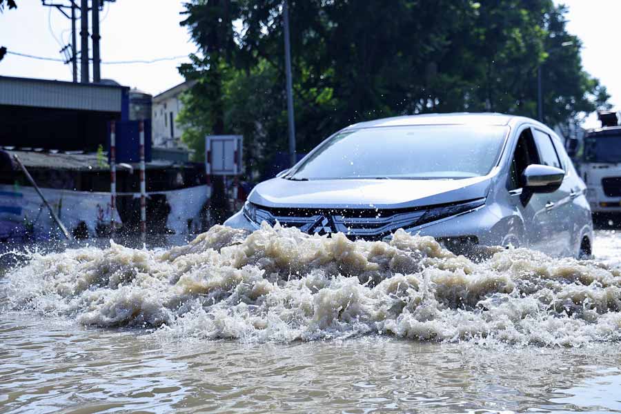 Không chỉ xe máy, ô tô cũng phải chật vật lội nước. Mực nước ngập đến nửa thân ô tô.