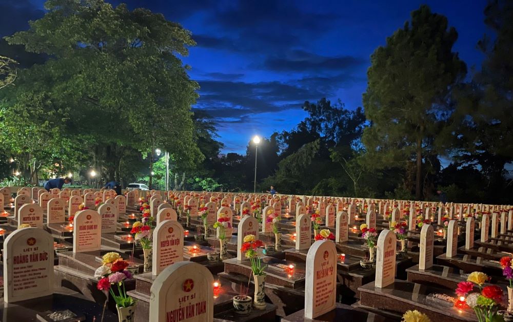 Candles are lit at martyrs' graves on the night of July 26. Photo: T. Nhat.