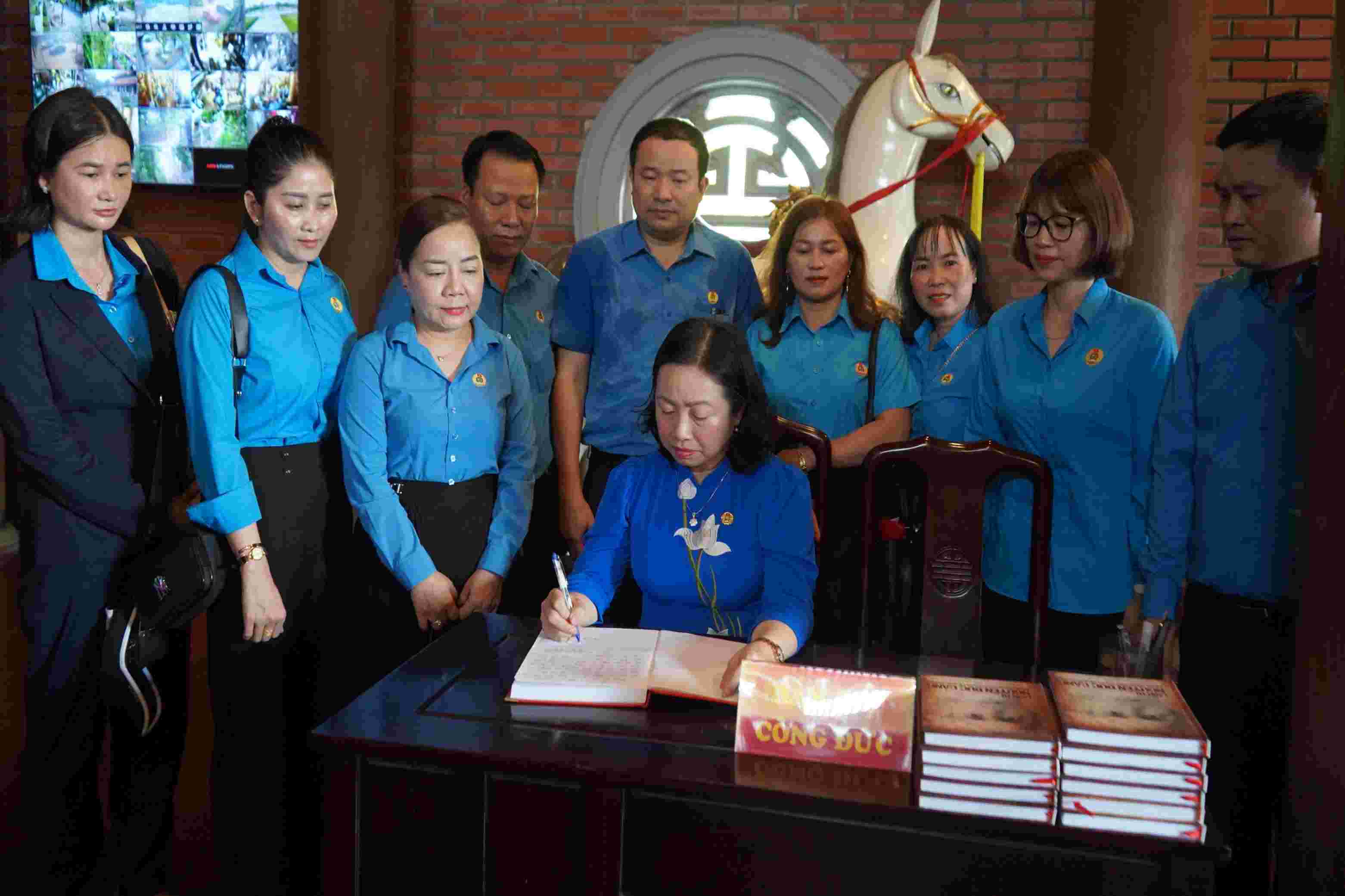 Permanent Vice Chairman of the Vietnam General Confederation of Labor writes a souvenir book at the memorial house for comrade Nguyen Duc Canh. Photo: Mai Dung