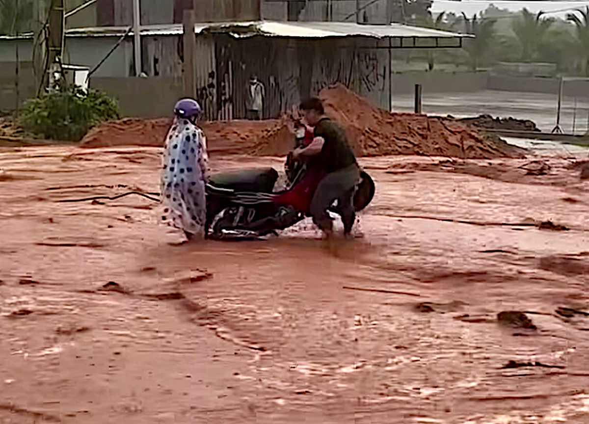 Carrying the motorbike out of the flowing sand. Photo: NDCC