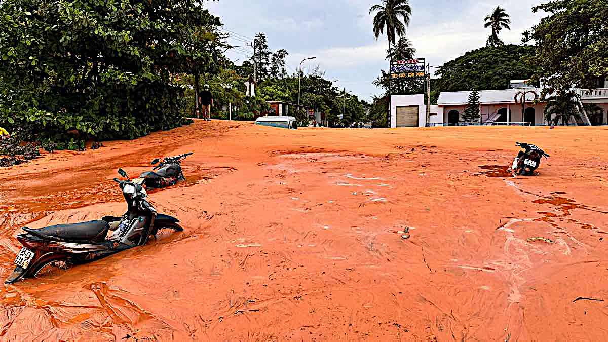 Sand flowed down the road, covering a 16-seat car and many motorbikes on the morning of May 21. Photo: Duy Tuan