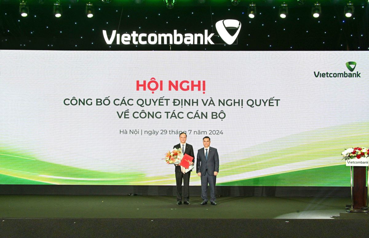 Mr. Nguyen Thanh Tung - Secretary of the Party Committee, Chairman of the BOD of Vietcombank (right) presents the Decision and congratulatory flowers to Mr. Le Quang Vinh. Photo: Vietcombank.