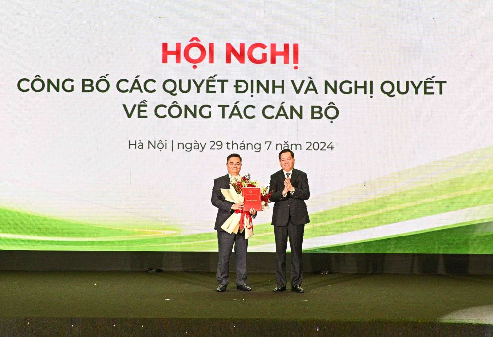 Mr. Nguyen Long Hai - Alternate Member of the Central Committee of the Party, Secretary of the Party Committee of the DNTW (right) presents the Decision and congratulatory flowers to Mr. Nguyen Thanh Tung, the new Secretary of the Party Committee of Vietcombank. Photo: Vietcombank.