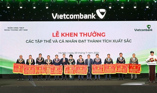 Đồng chí Phạm Quang Dũng - Ủy viên Ban cán sự Đảng, Phó Thống đốc NHNN Việt Nam (thứ 6, từ trái sang) - trao Cờ và đồng chí Nguyễn Thanh Tùng - Chủ tịch HĐQT Vietcombank (thứ 5 từ phải sang) tặng hoa chúc mừng 11 tập thể vinh dự nhận Cờ thi đua của NHNN Việt Nam. Ảnh: Vietcombank