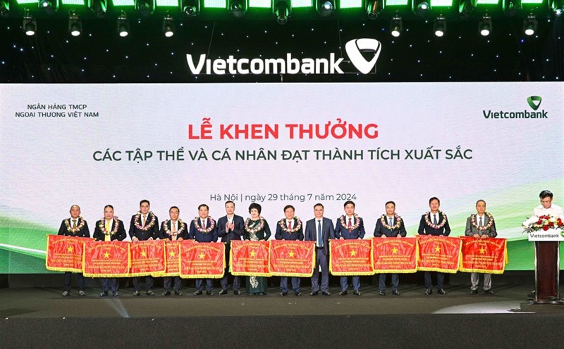 Đồng chí Phạm Quang Dũng - Ủy viên Ban cán sự Đảng, Phó Thống đốc NHNN Việt Nam (thứ 6, từ trái sang) - trao Cờ và đồng chí Nguyễn Thanh Tùng - Chủ tịch HĐQT Vietcombank (thứ 5 từ phải sang) tặng hoa chúc mừng 11 tập thể vinh dự nhận Cờ thi đua của NHNN Việt Nam. Ảnh: Vietcombank