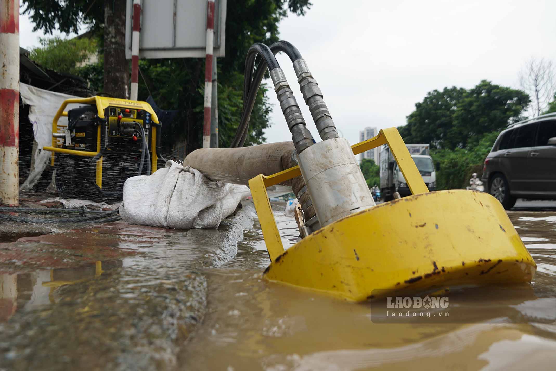 Workers of Hanoi Drainage Company Limited continuously arrange people to be on duty to warn passing vehicles. At the same time, use a specialized pump to suck up water, but the water level still recedes quite slowly.