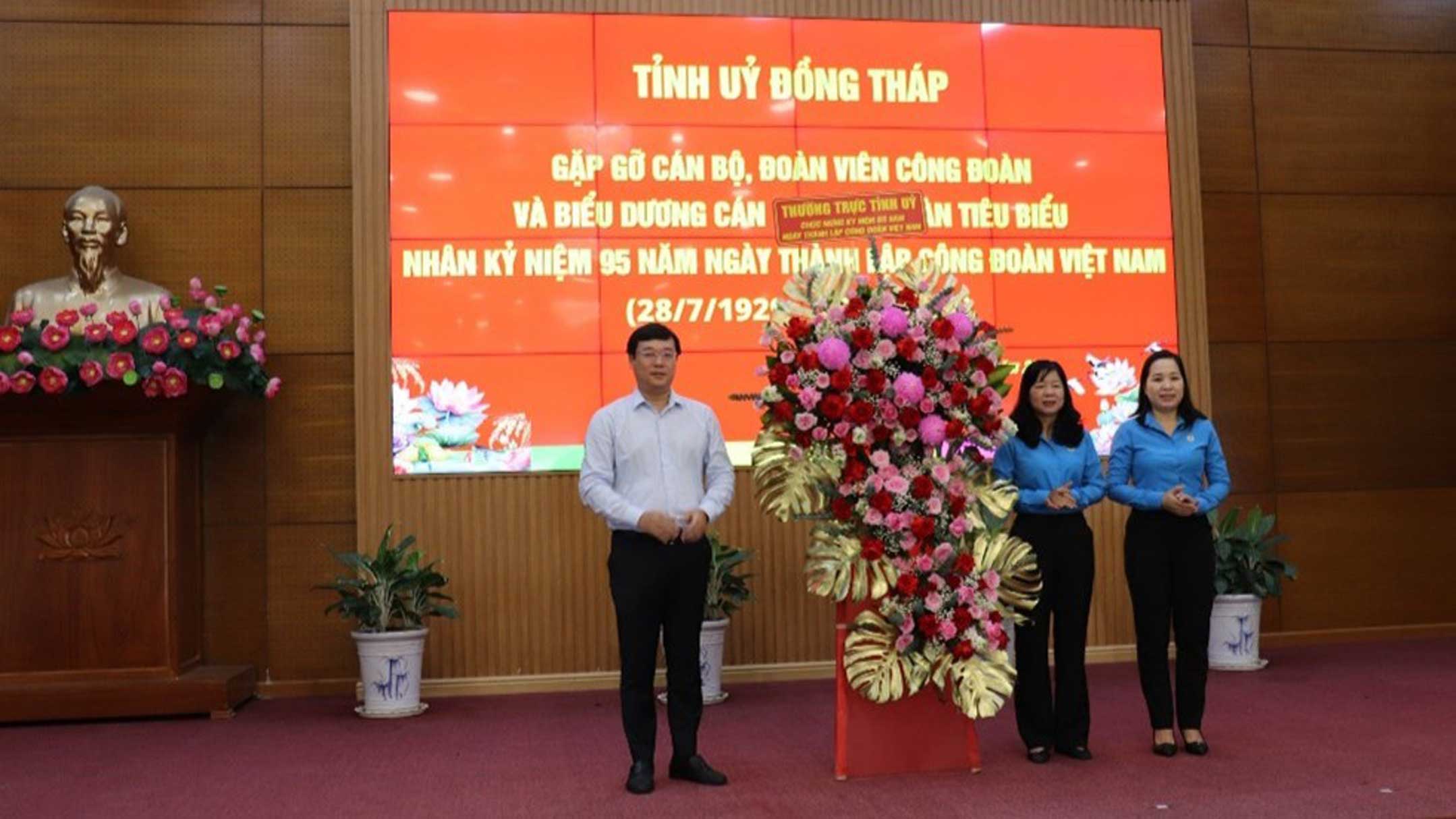 Provincial Party Secretary Le Quoc Phong presented a congratulatory flower basket at the meeting. Photo: Luu Hung