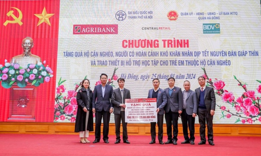 Đồng chí Phạm Đức Ấn - Bí thư Đảng ủy, Chủ tịch HĐTV Agribank trao tặng quà của Agribank hỗ trợ hộ cận nghèo, đối tượng chính sách quận Hà Đông (Hà Nội) nhân dịp Tết Nguyên đán Giáp Thìn. Nguồn: Agribank 