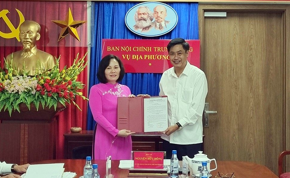 Ông Nguyễn Hữu Đông - Ủy viên Trung ương Đảng, Phó Trưởng Ban Nội chính Trung ương - trao Quyết định, chúc mừng bà Phan Thị Hồng, Phó Vụ trưởng Vụ Địa phương III. Ảnh: VGP