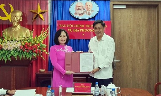Ông Nguyễn Hữu Đông - Ủy viên Trung ương Đảng, Phó Trưởng Ban Nội chính Trung ương - trao Quyết định, chúc mừng bà Phan Thị Hồng, Phó Vụ trưởng Vụ Địa phương III. Ảnh: VGP