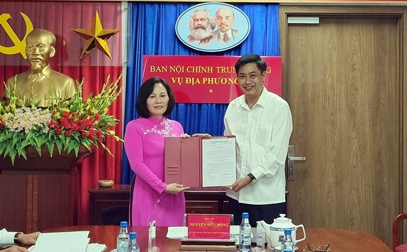 Ông Nguyễn Hữu Đông - Ủy viên Trung ương Đảng, Phó Trưởng Ban Nội chính Trung ương - trao Quyết định, chúc mừng bà Phan Thị Hồng, Phó Vụ trưởng Vụ Địa phương III. Ảnh: VGP