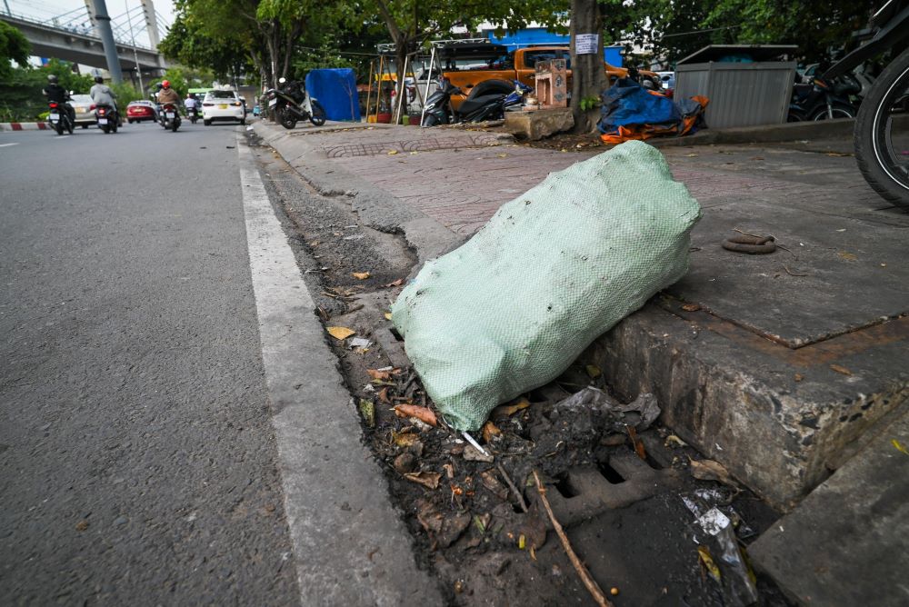 Garbage bags block half of the manhole on Huynh Tan Phat Street (District 7) - a flooding point in Ho Chi Minh City every time it rains heavily. “Every night, until they finish cleaning up their goods, the street vendors dump all their trash into the manhole. When it rains, garbage flows down the drain, clogging it and flooding the road. People here have complained many times but to no avail," said Mr. Le Duc Dung, who lives along the road.