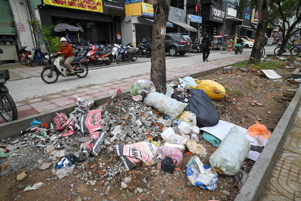 Bags of household garbage, all kinds of debris... are piled up on the sidewalks of District 1, causing loss of urban beauty. Photo: Minh Tam