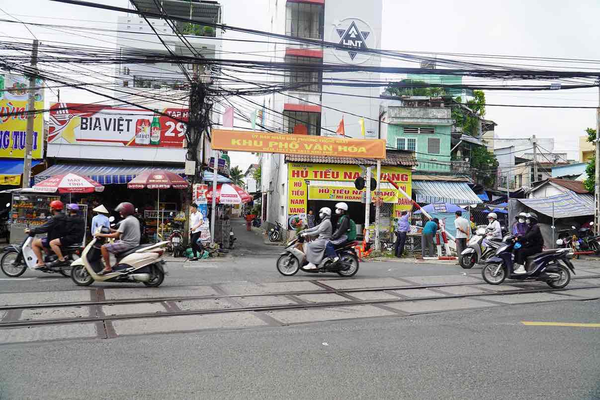 Nhiều hàng quán buôn bán ngay đường ray và nằm phía bên trong của gác chắn. Ảnh: HAC