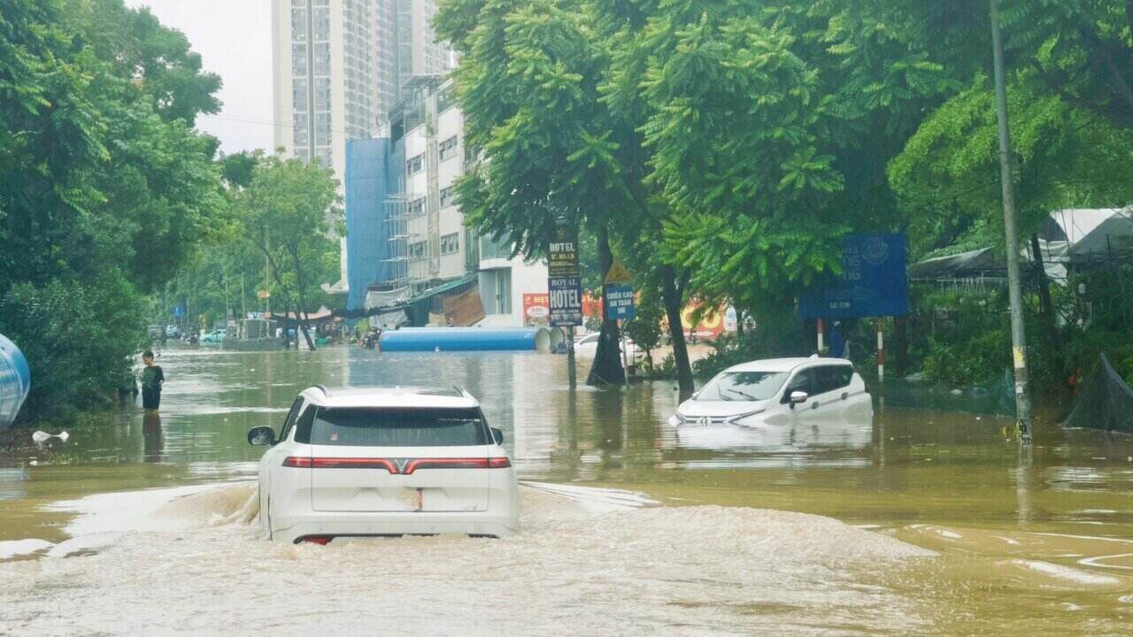 Tại khu vực đường gom đại lộ Thăng Long (đoạn đối diện đường Lê Trọng Tấn vào công viên Thiên Đường Bảo Sơn), nước ngập sâu từ 30 - 60cm khiến tuyến đường này biến thành sông. Ảnh: Lâm Phú