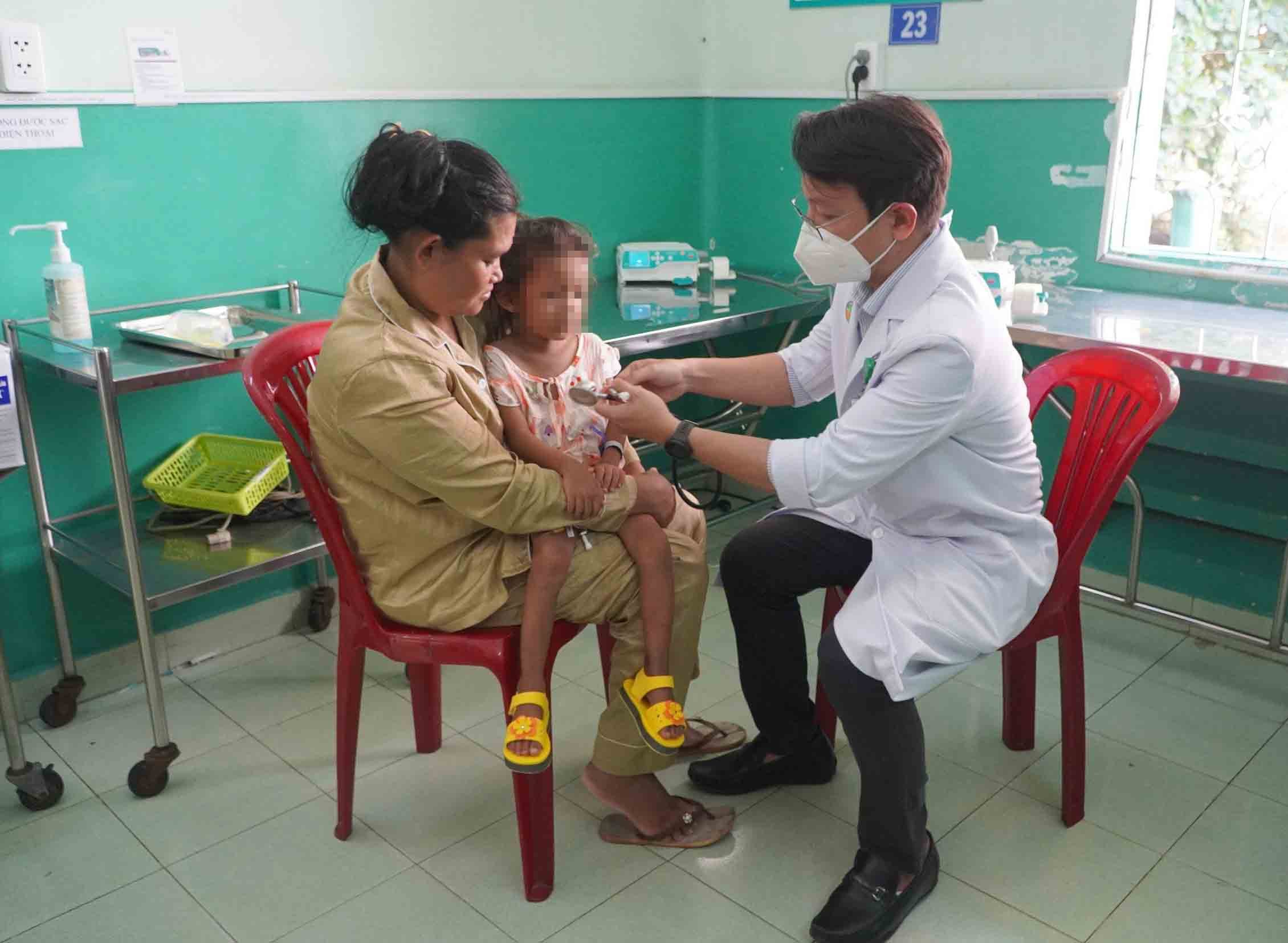 Bệnh nhi bị sốt xuất huyết đang được bác sĩ tại TPHCM thăm khám. Ảnh: CHÂN PHÚC