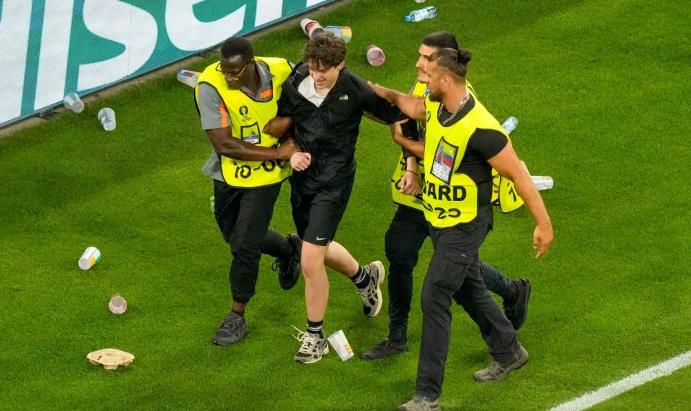 Một số trường hợp chạy vào sân, trong khi cổ động viên nhiều đội ném đồ xuống sân khi không hài lòng. Ảnh: UEFA