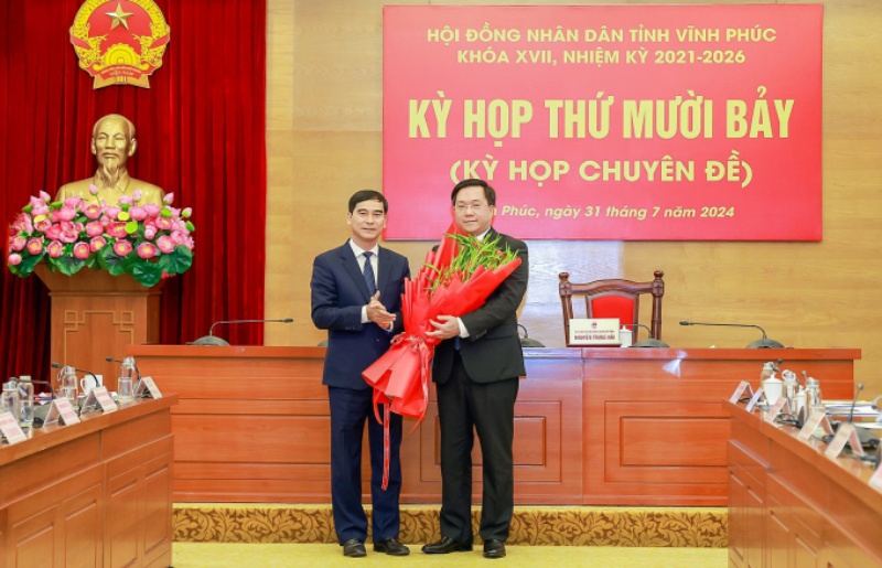 Tân Chủ tịch UBND tỉnh Vĩnh Phúc Trần Duy Đông (phải) nhận hoa chúc mừng từ Bí thư Tỉnh ủy Vĩnh Phúc Dương Văn An. Ảnh: BaoVinhPhuc