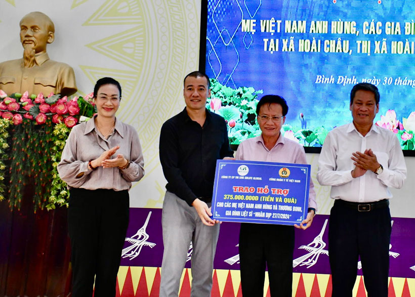 Phó Chủ tịch Huỳnh Thanh Xuân (bên phải) chứng kiến trao biểu trưng hỗ trợ cho lãnh đạo thị xã Hoài Nhơn. Ảnh: Xuân Nhàn. 