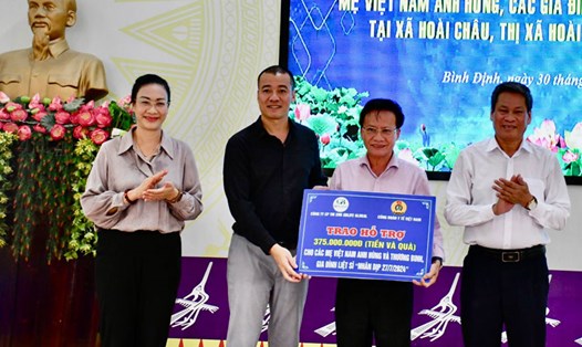 Phó Chủ tịch Huỳnh Thanh Xuân (bên phải) chứng kiến trao biểu trưng hỗ trợ cho lãnh đạo thị xã Hoài Nhơn. Ảnh: Xuân Nhàn.