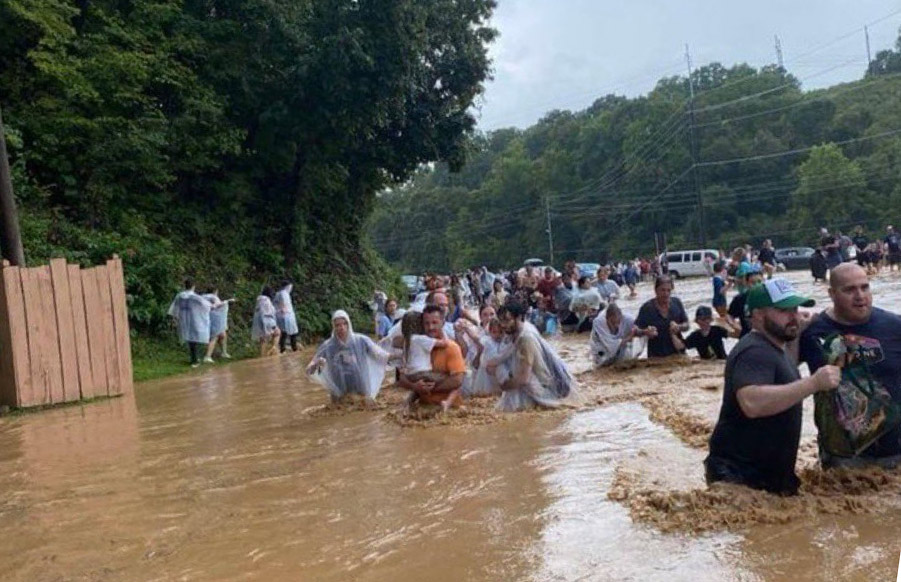 Tourists wading through floodwaters. Photo: NelsonWDVX/X