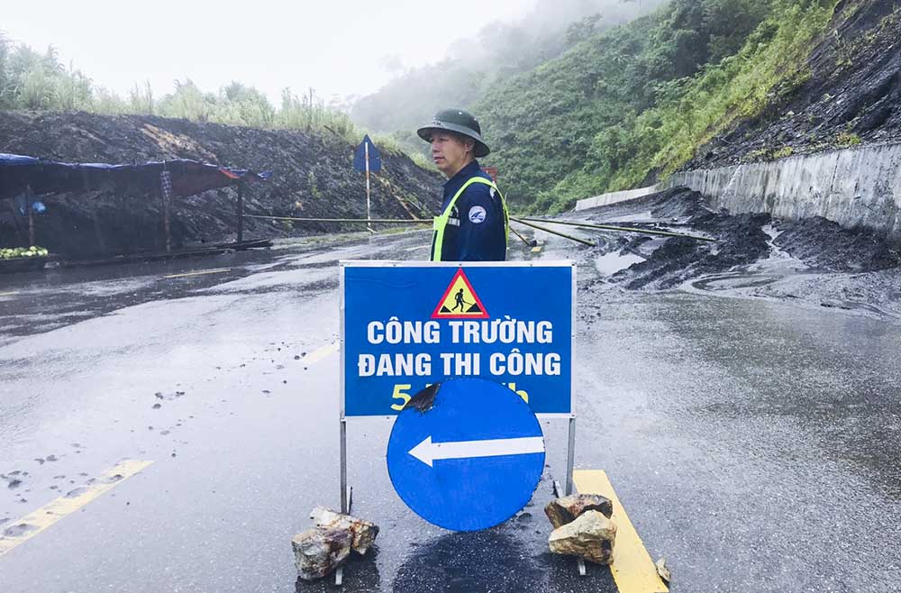 Authorities place warning signs and regulate traffic. Photo: Quoc Huy