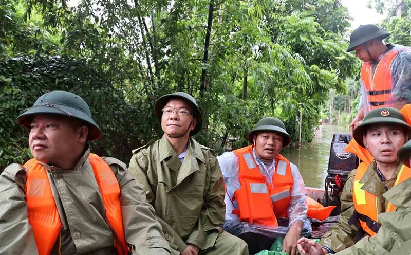 Đoàn công tác của Phó Thủ tướng Chính phủ Lê Thành Long đi xuồng thị sát vùng ngập lụt ở Chương Mỹ và đến thăm hỏi đời sống bà con. Ảnh: Đức Tuân