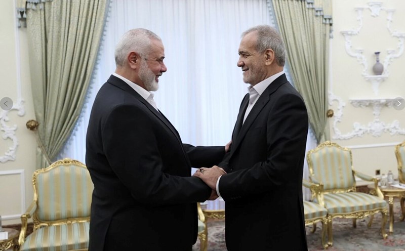 Tổng thống Iran Masoud Pezeshkian (phải) bắt tay thủ lĩnh Hamas Ismail Haniyeh trong cuộc gặp ngày 30.7. Ảnh: Văn phòng Tổng thống Iran