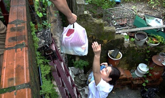 Một gia đình tại tổ 28, khu 2B, phường Cao Xanh, TP Hạ Long, tỉnh Quảng Ninh đang trèo thang chuyển quần áo đi giặt. Ảnh: Đoàn Hưng