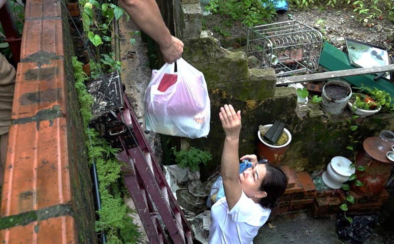 Một gia đình tại tổ 28, khu 2B, phường Cao Xanh, TP Hạ Long, tỉnh Quảng Ninh đang trèo thang chuyển quần áo đi giặt. Ảnh: Đoàn Hưng